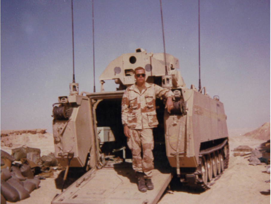 2LT Ford stands behind his Fire Support Team Vehicle (FISTV) in Saudi Arabia during Operation Desert Shield. The device on top of the vehicle is a laser guidance system.